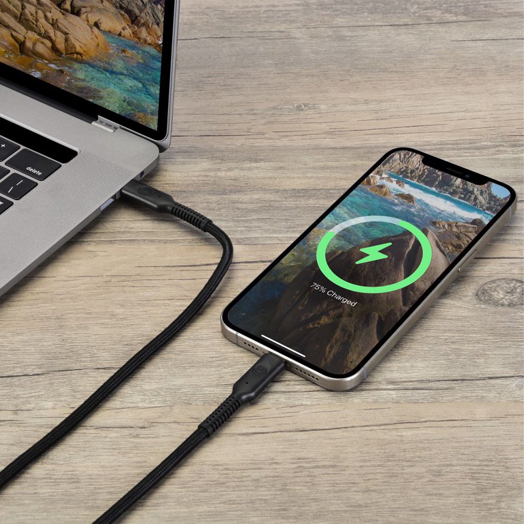 Black USB-C cable connecting a laptop and a smartphone on a wooden surface