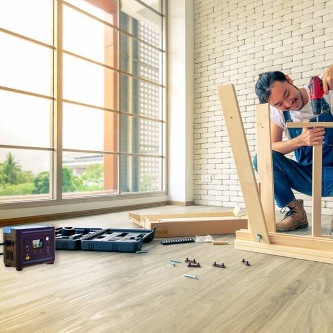 Man assembling furniture with a power station and tools on the floor