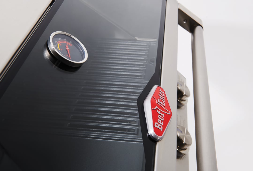 Close up of a BeefEater built-in BBQ with a temperature gauge and logo