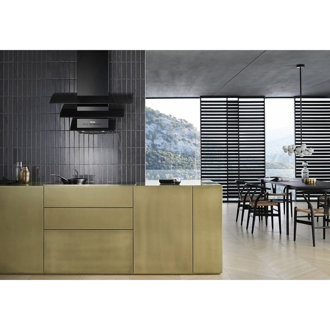 Black range hood above a gold kitchen island in a modern home