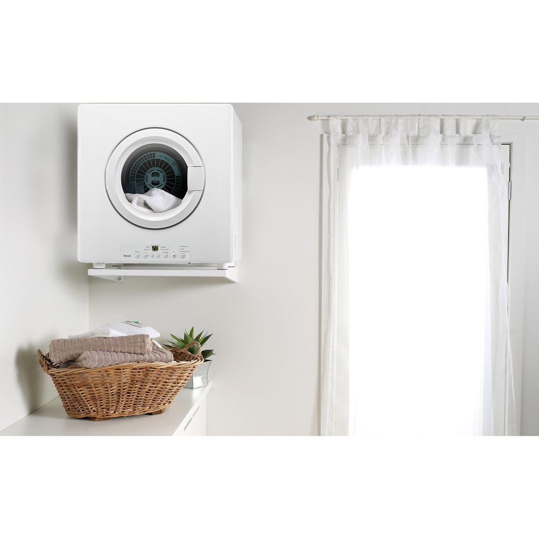 White dryer with an open door in a laundry room with a window