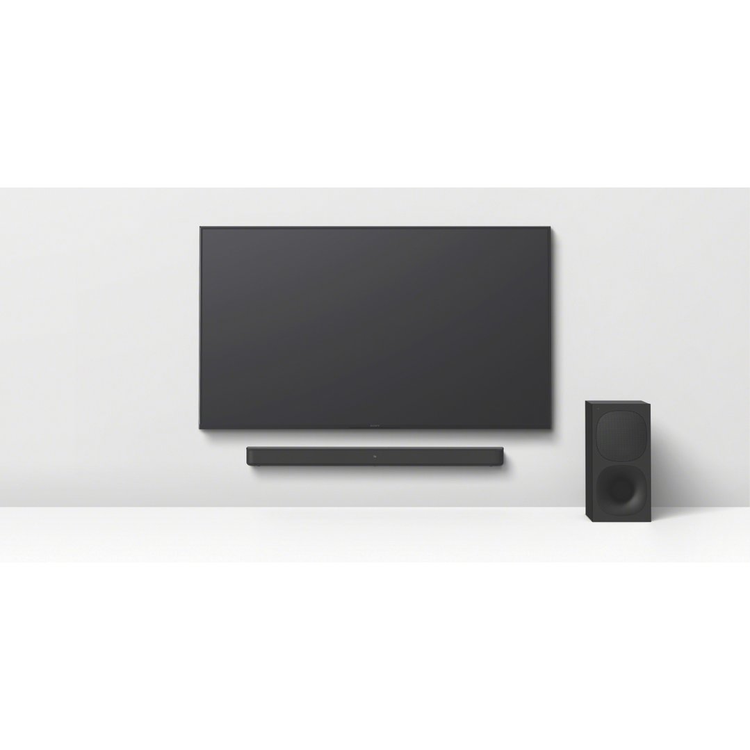 A black soundbar and subwoofer in front of a wall-mounted TV