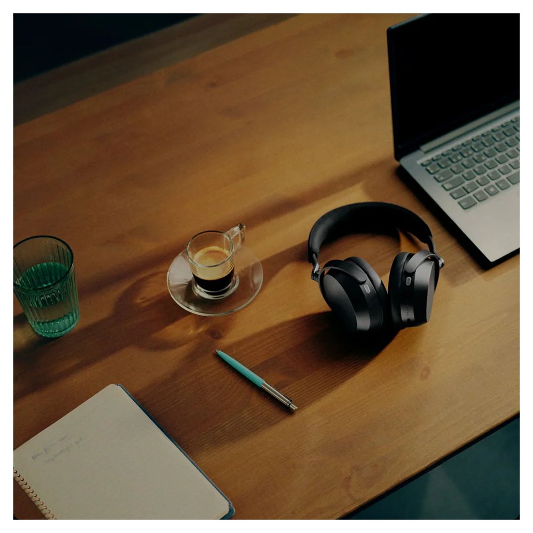 Sennheiser Momentum 5 headphones on a wooden desk with a laptop and coffee