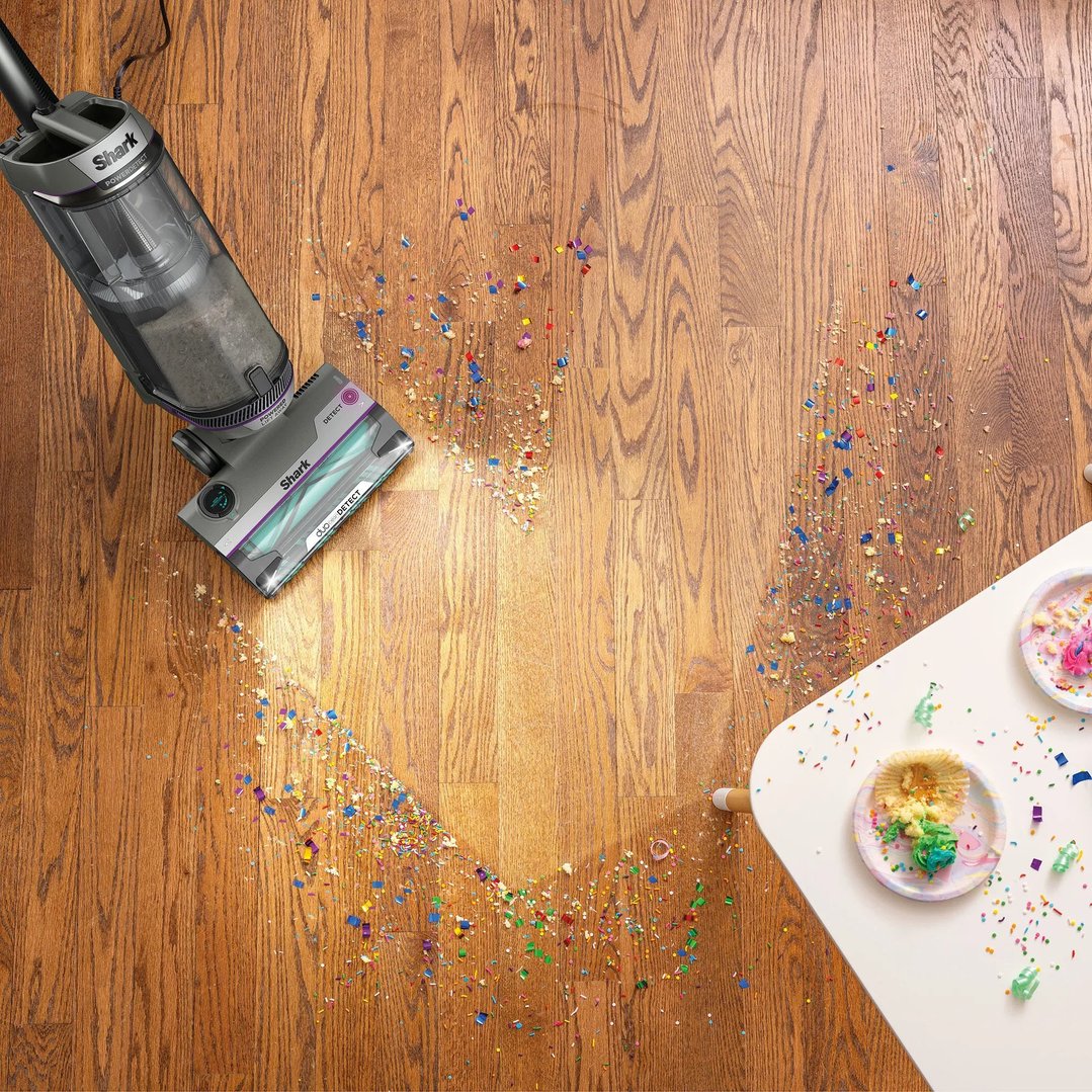 Shark PowerDetect vacuum cleaner cleaning colorful confetti and crumbs from a wooden floor