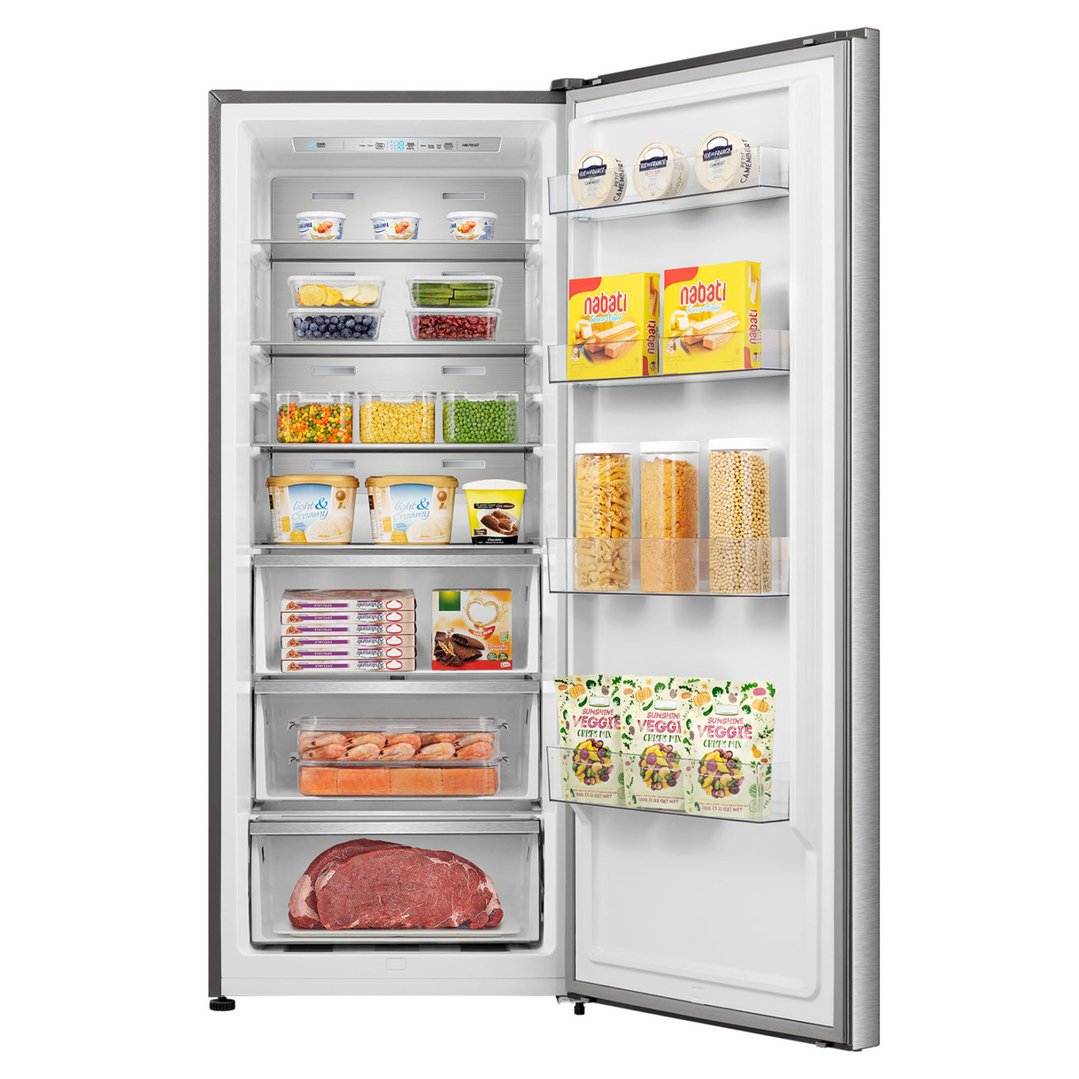 Open stainless steel freezer filled with various food items in a kitchen setting