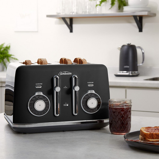 A black Sunbeam 4-slice toaster on a kitchen counter with toast and jam