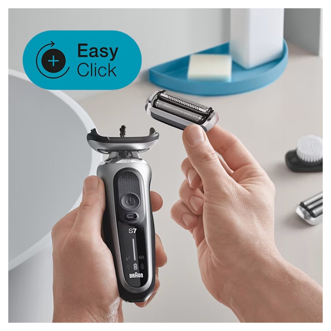 Hands holding a Braun shaver and a replacement head in a bathroom setting