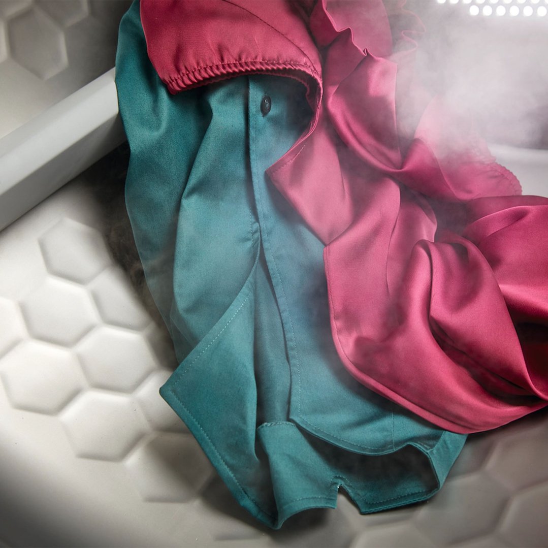 Two garments, one teal and one magenta, with steam rising from them