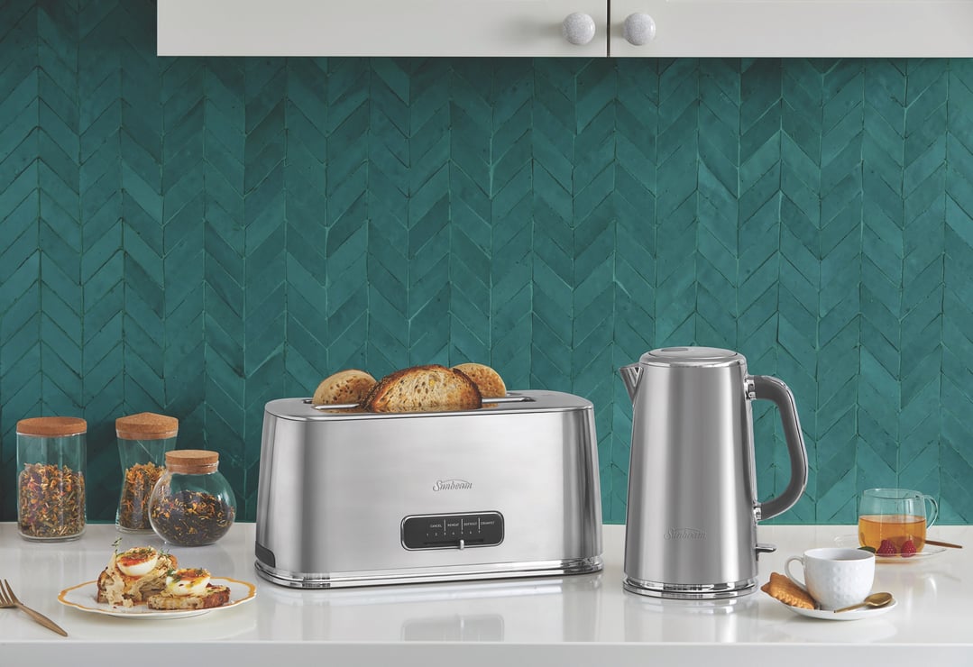 Sunbeam toaster and kettle on a kitchen counter with toast, tea, and spices