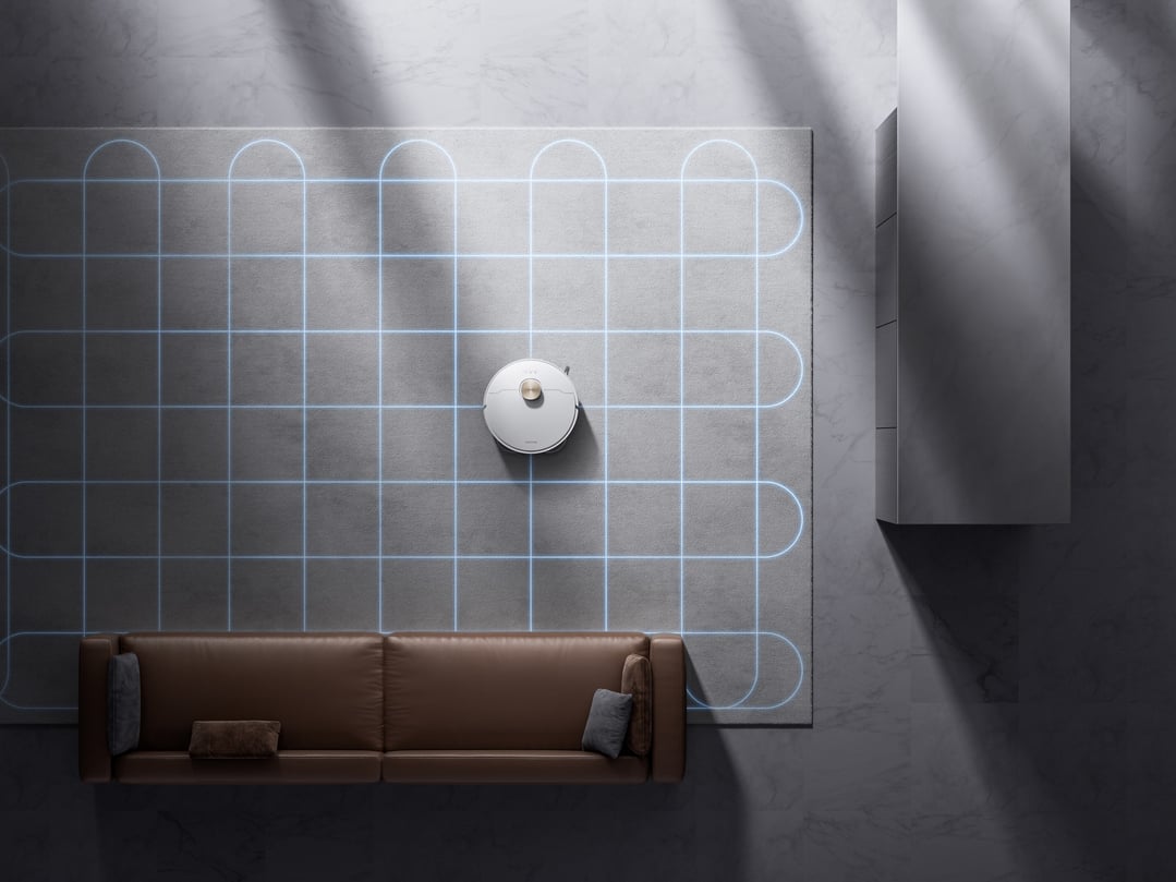 White robot vacuum and mop cleaning a grey rug in a living room