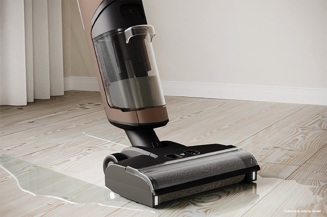 Wet and dry vacuum cleaner cleaning a wet wooden floor in a room