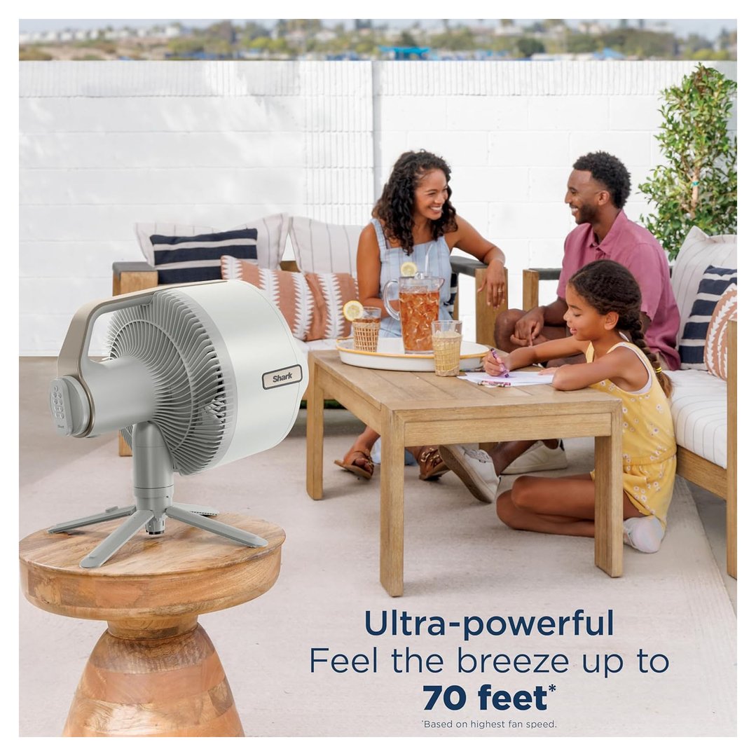 A family relaxing outdoors with a Shark fan on a wooden table