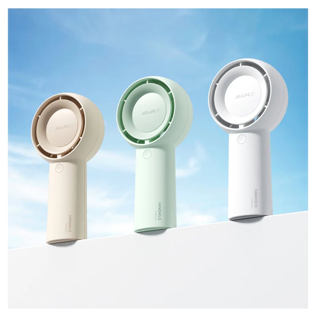 Three JISULIFE handheld fans in different colors on a white surface outdoors