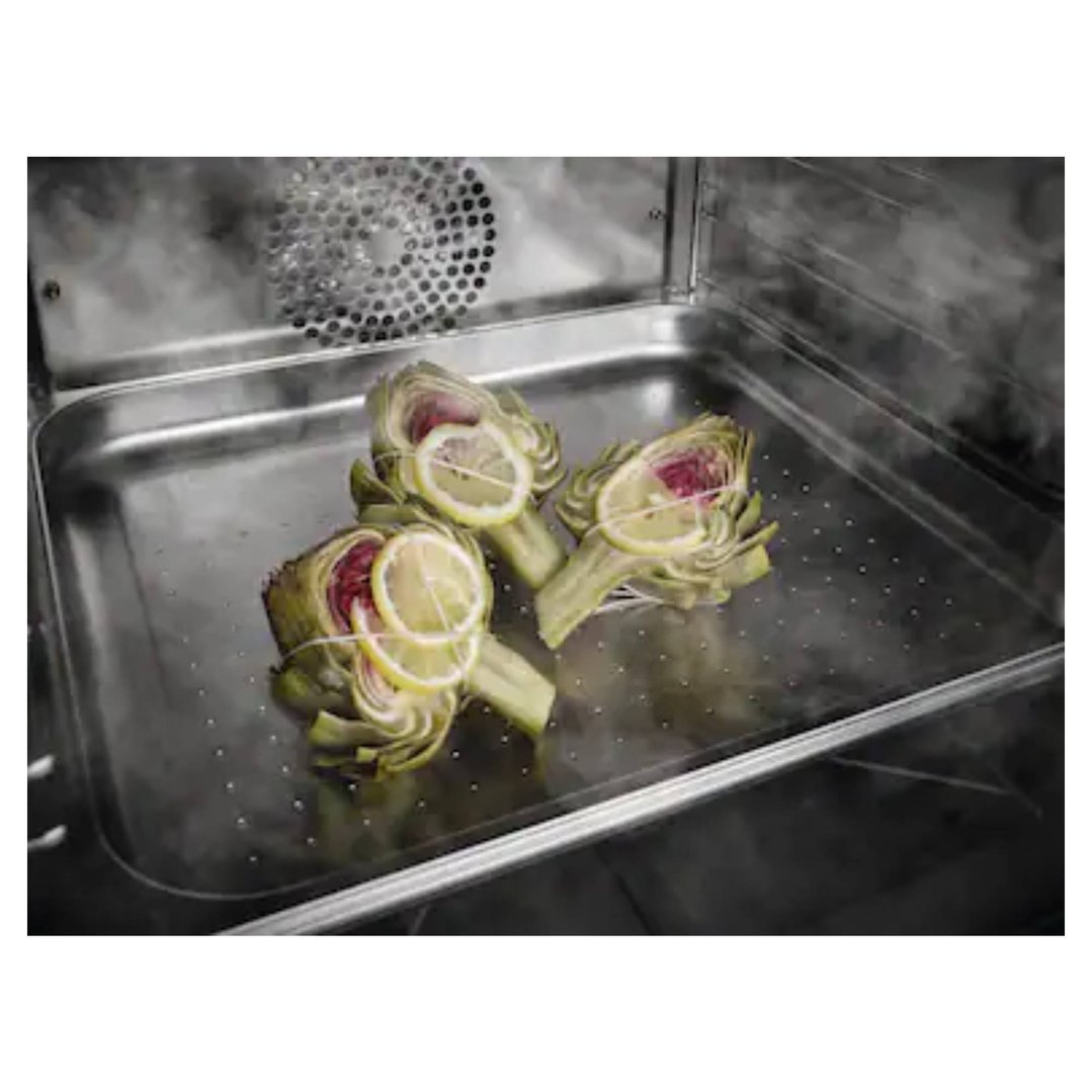 Three artichokes with lemon slices steaming in a combination steam oven