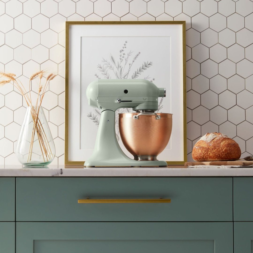 KitchenAid stand mixer with copper bowl on a kitchen counter with bread and vase
