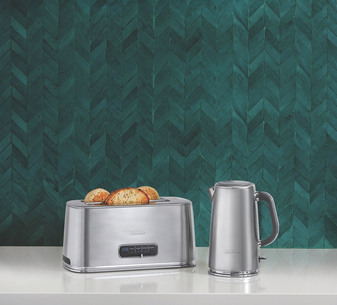 A Sunbeam toaster and kettle on a white countertop with a teal tiled wall