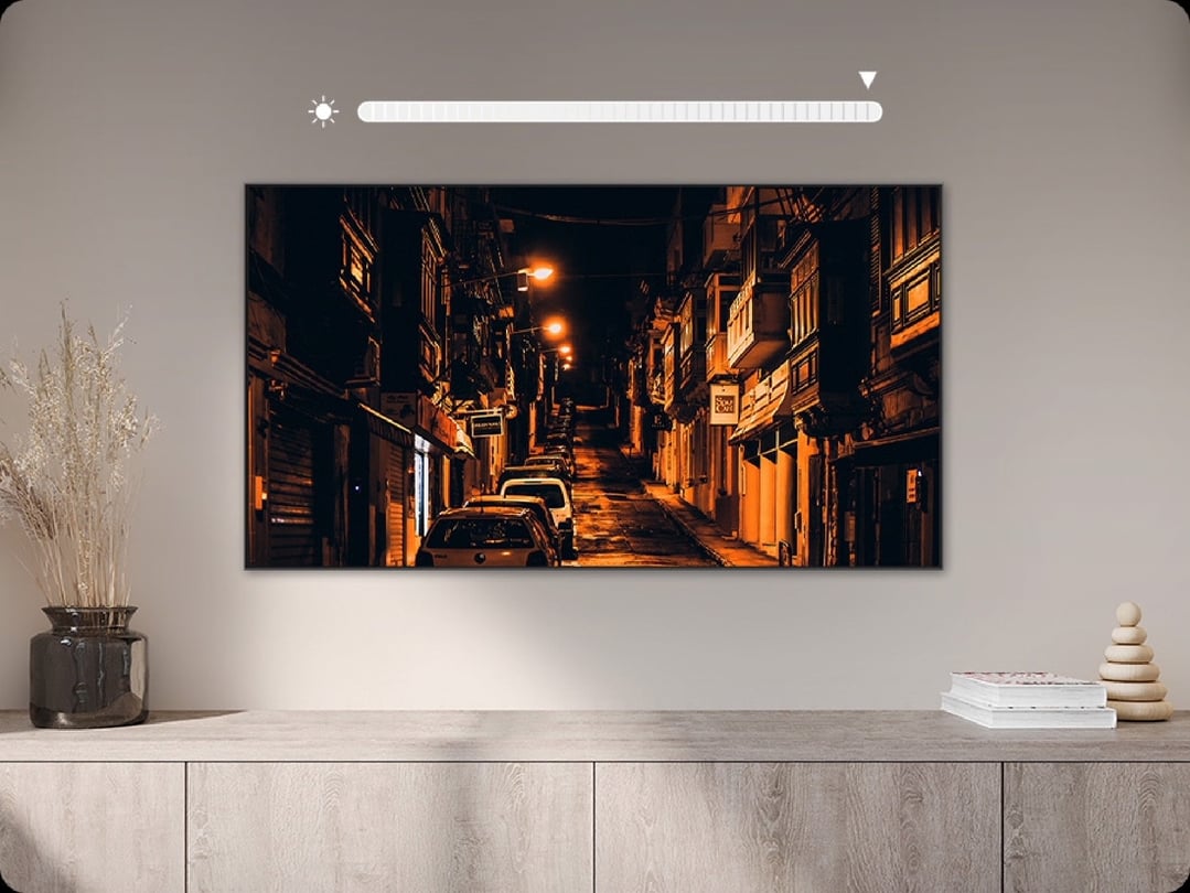 A SAMSUNG TV displaying a night street scene, on a wooden cabinet