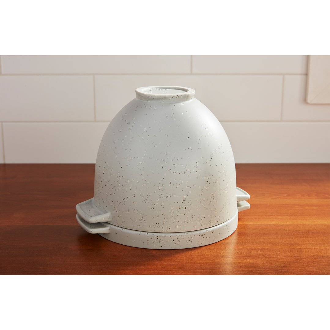 A KitchenAid Artisan Bread Bowl on a wooden surface with a tiled background