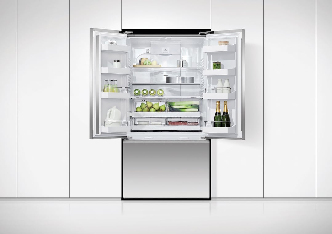 Open French door refrigerator freezer with food and drinks inside, built into white cabinetry
