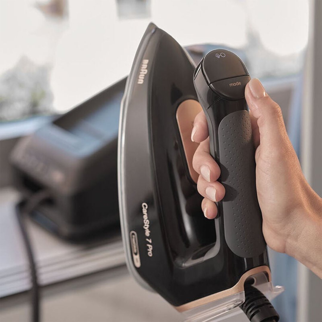 A hand holding a Braun CareStyle 7 Pro Steam Generator Iron