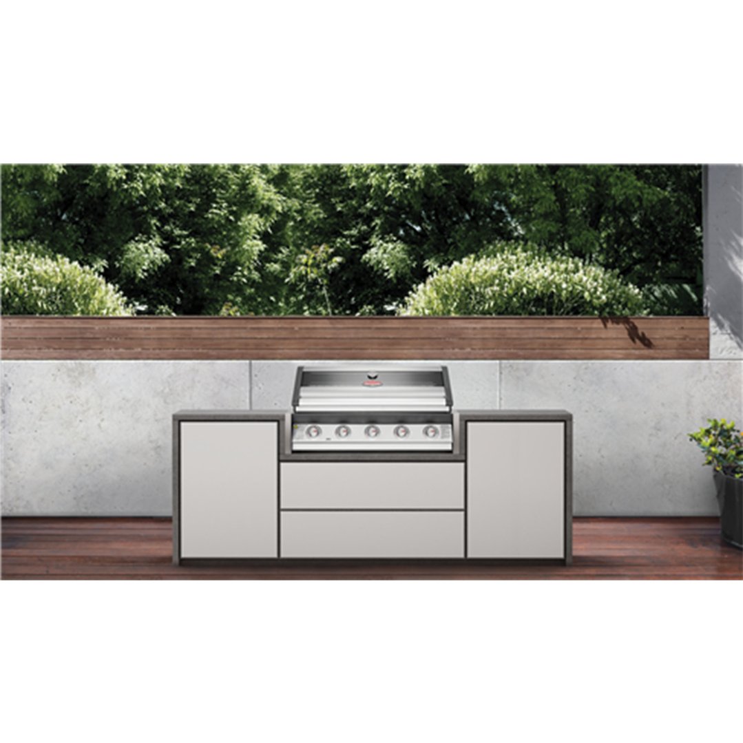 Built-in 5 burner barbecue in an outdoor kitchen setting with greenery
