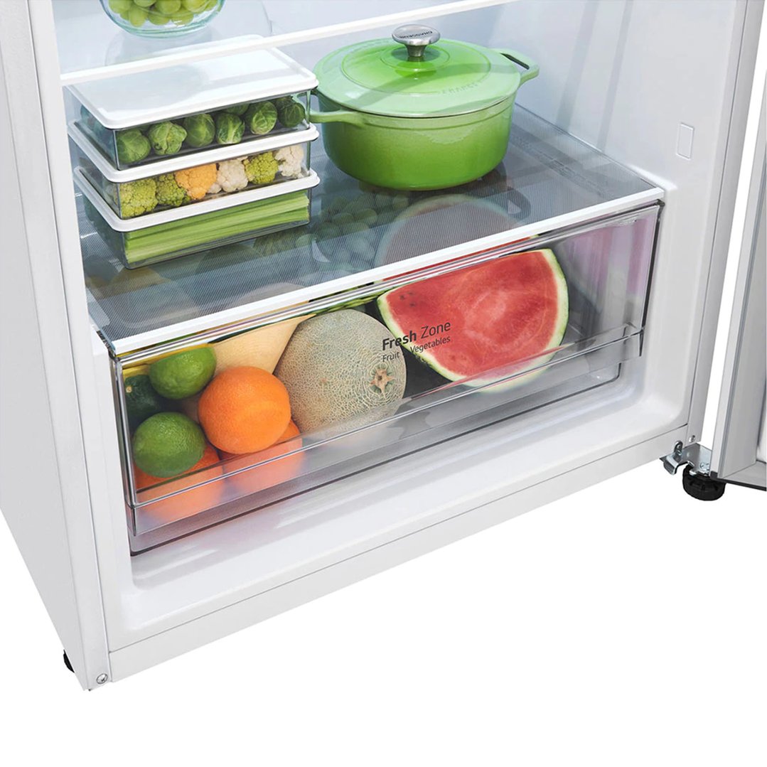 Interior of a white LG fridge with fresh produce and green cookware