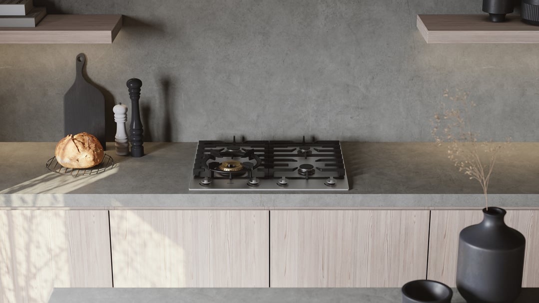 Stainless steel gas cooktop built into a grey kitchen countertop with props