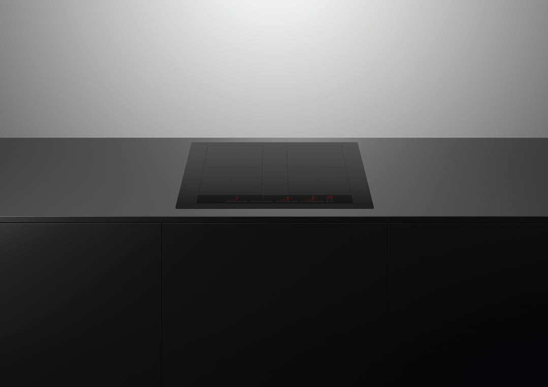 Black induction cooktop built into a dark countertop with dark cabinetry below