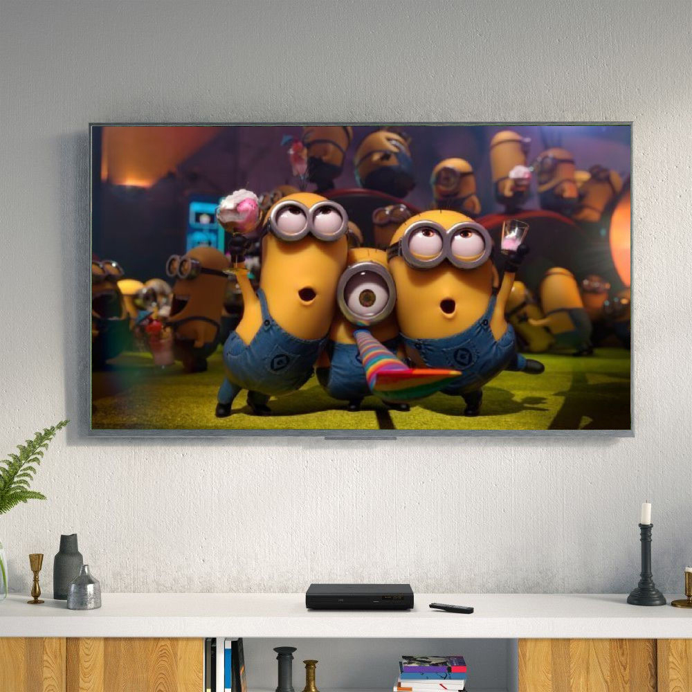DVD Player on a white shelf below a TV playing Minions movie