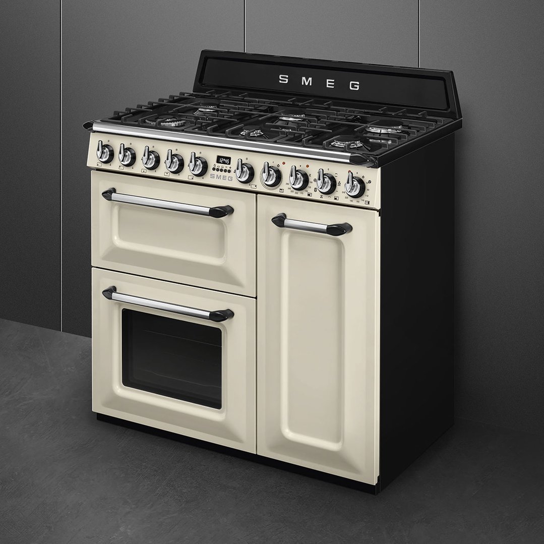 Cream freestanding cooker with black top and sides in a dark grey room