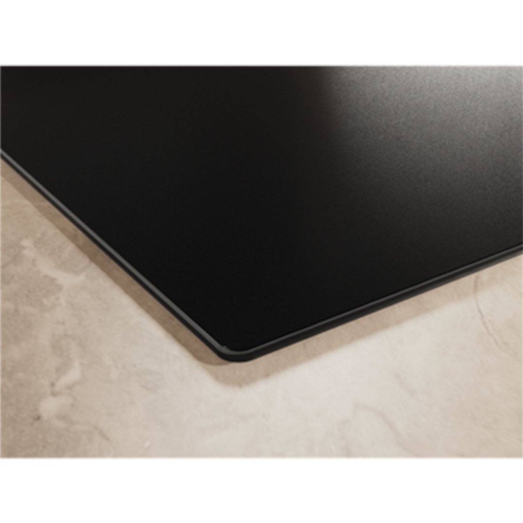 Close up of a matte black induction cooktop on a light-colored countertop