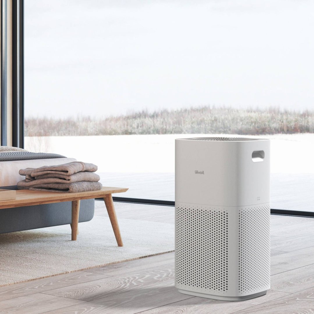 LEVOIT air purifier in a bedroom with a large window overlooking a snowy landscape