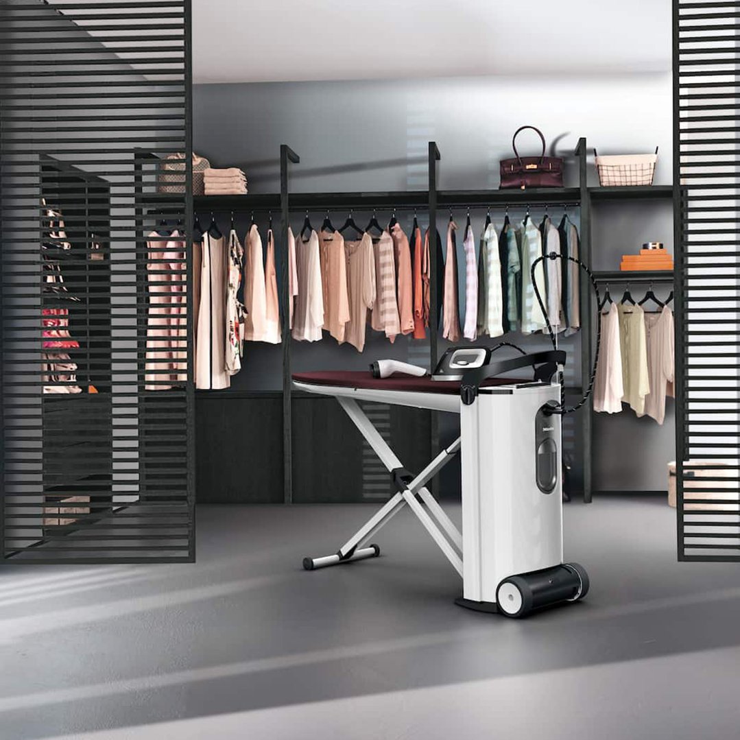 Fashion Master Steam Ironing System in a walk-in closet with clothes and accessories