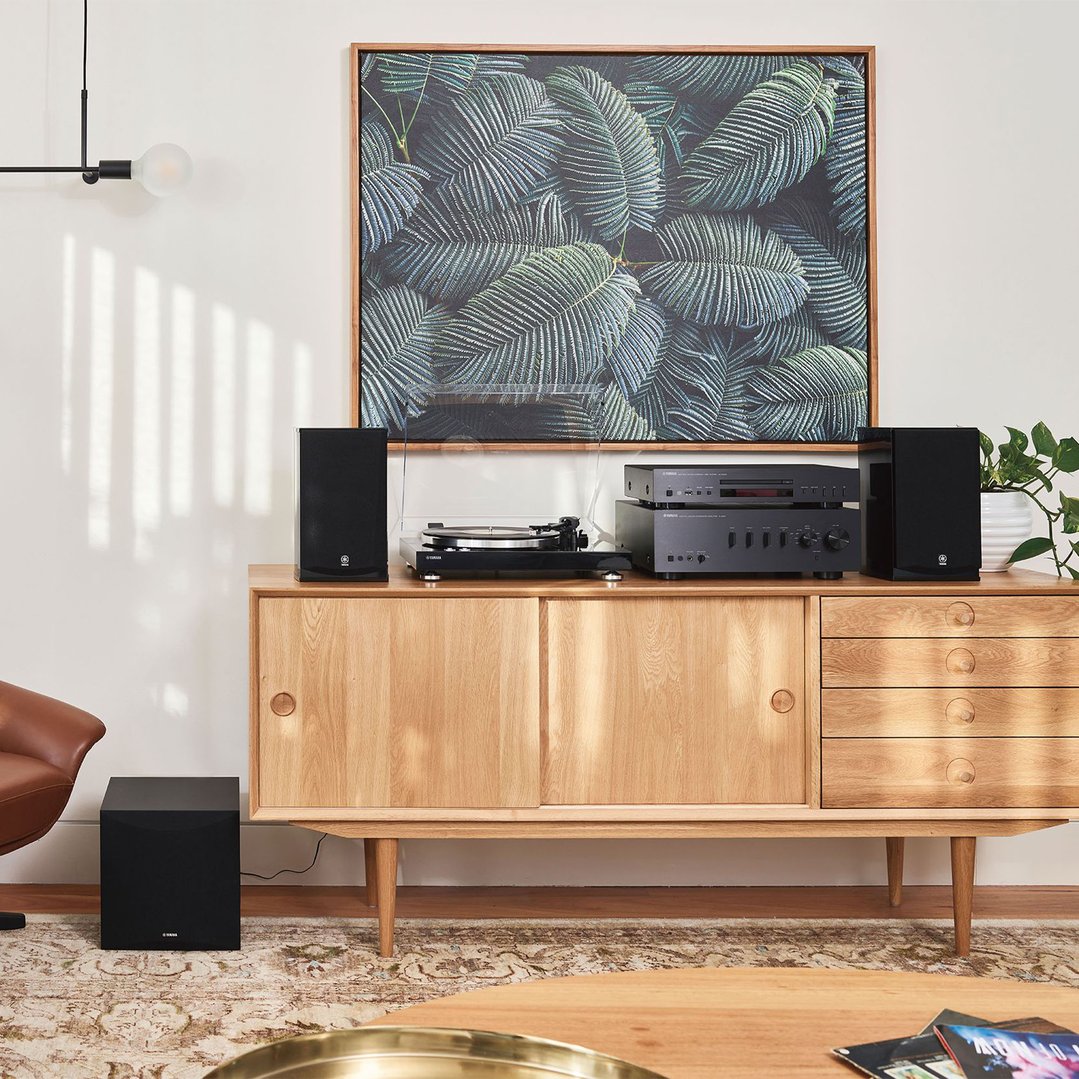 A Yamaha turntable and audio system on a wooden cabinet in a living room