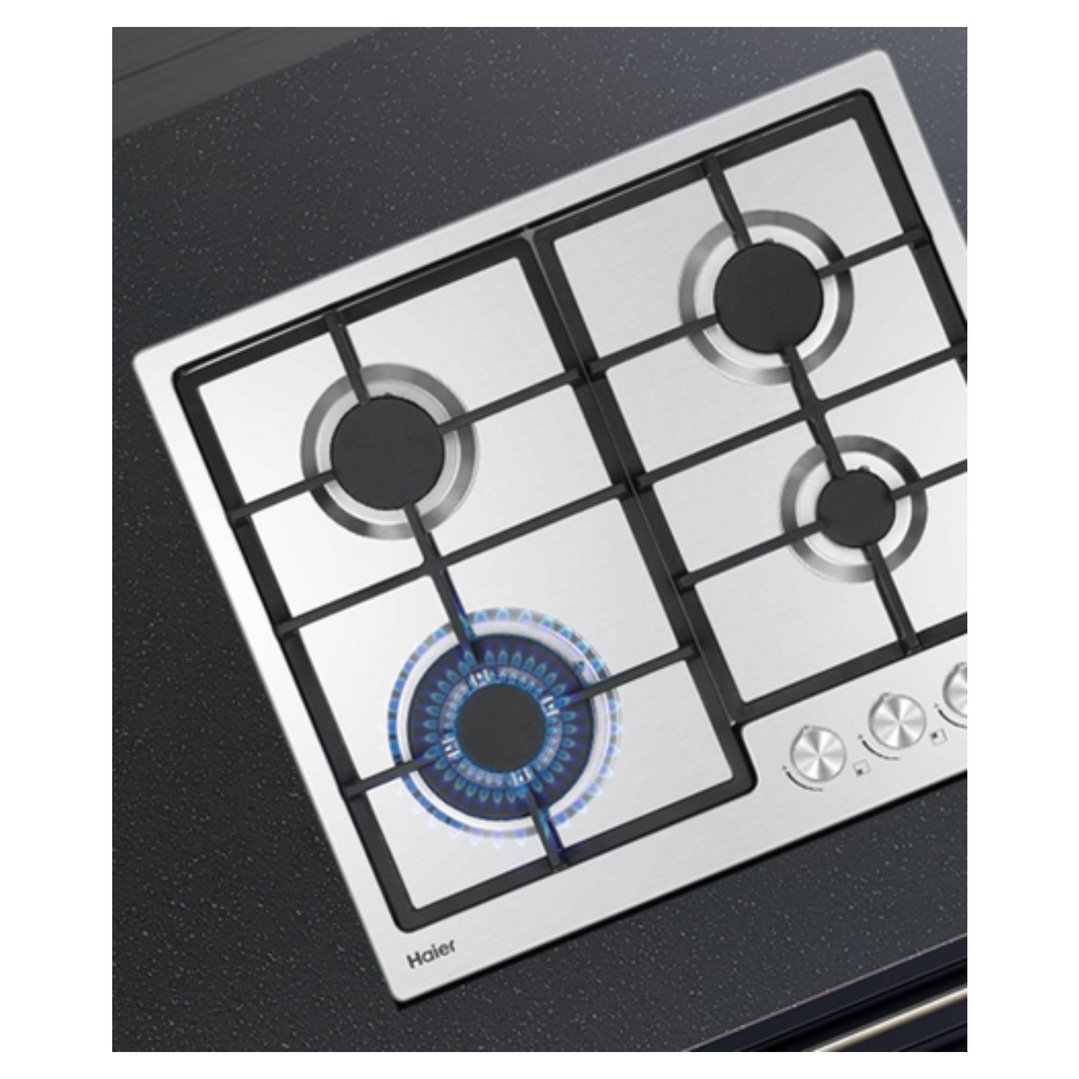 Haier 4 burner gas cooktop with one burner lit, built into a dark countertop