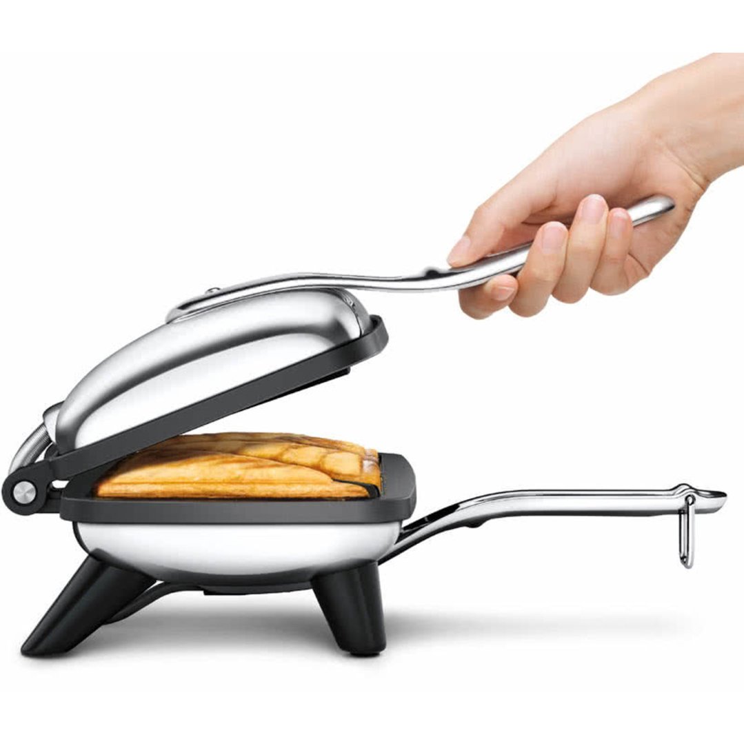 Hand opening a sandwich maker with a toasted sandwich inside on a white background