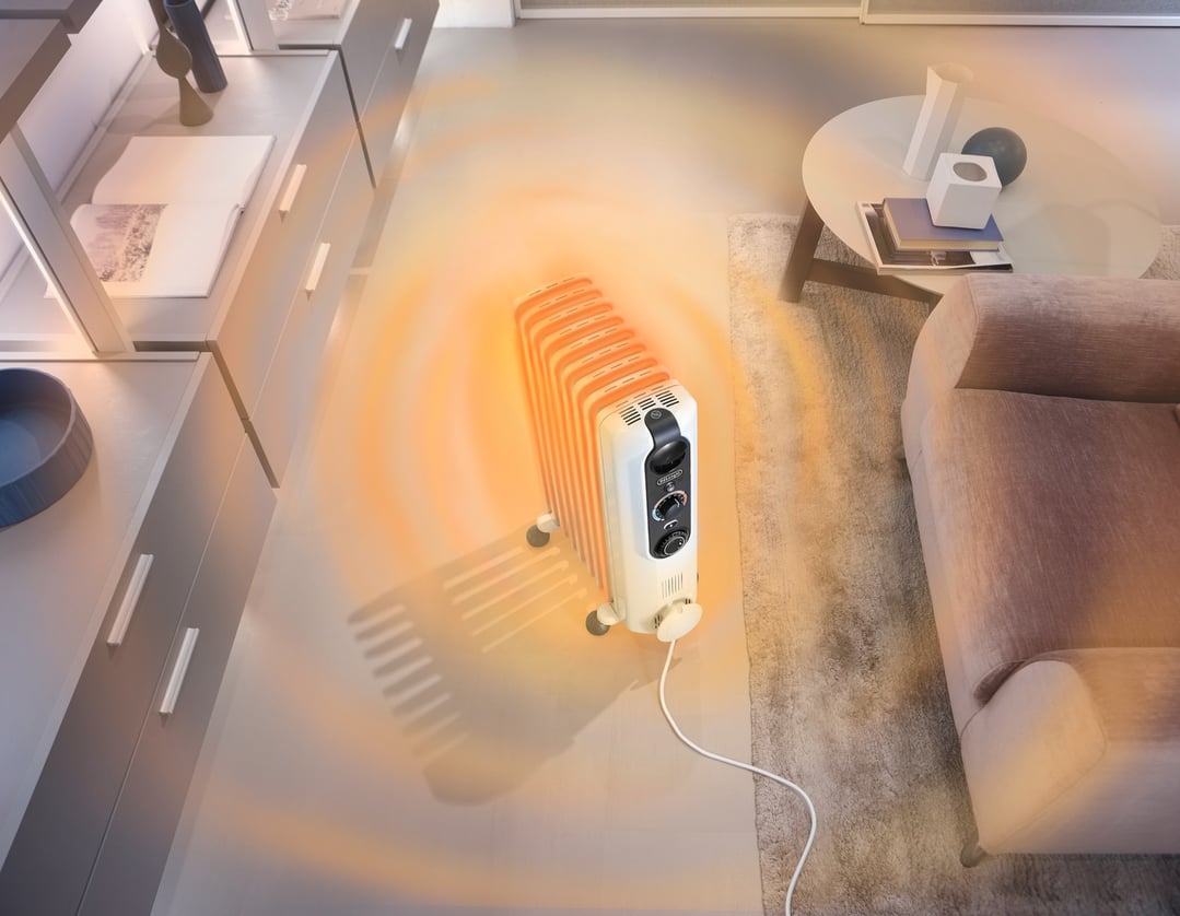 Oil column heater radiating heat in a modern living room setting