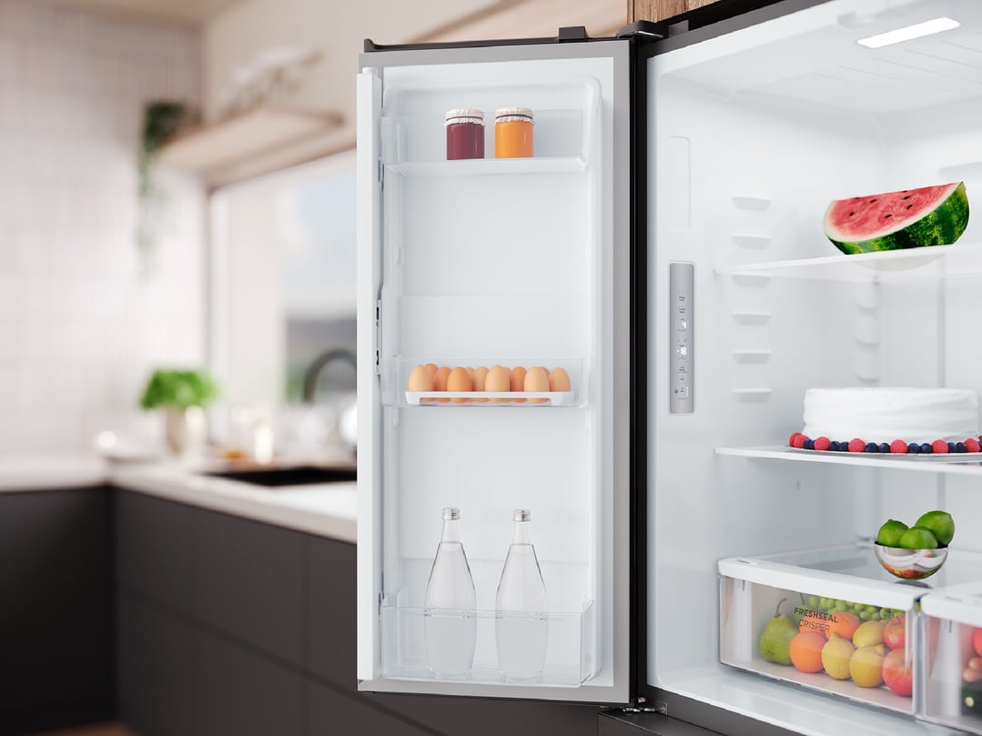 Open fridge with food items inside, in a modern kitchen setting