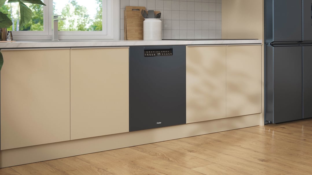 Black built-under dishwasher in a modern kitchen with light beige cabinetry