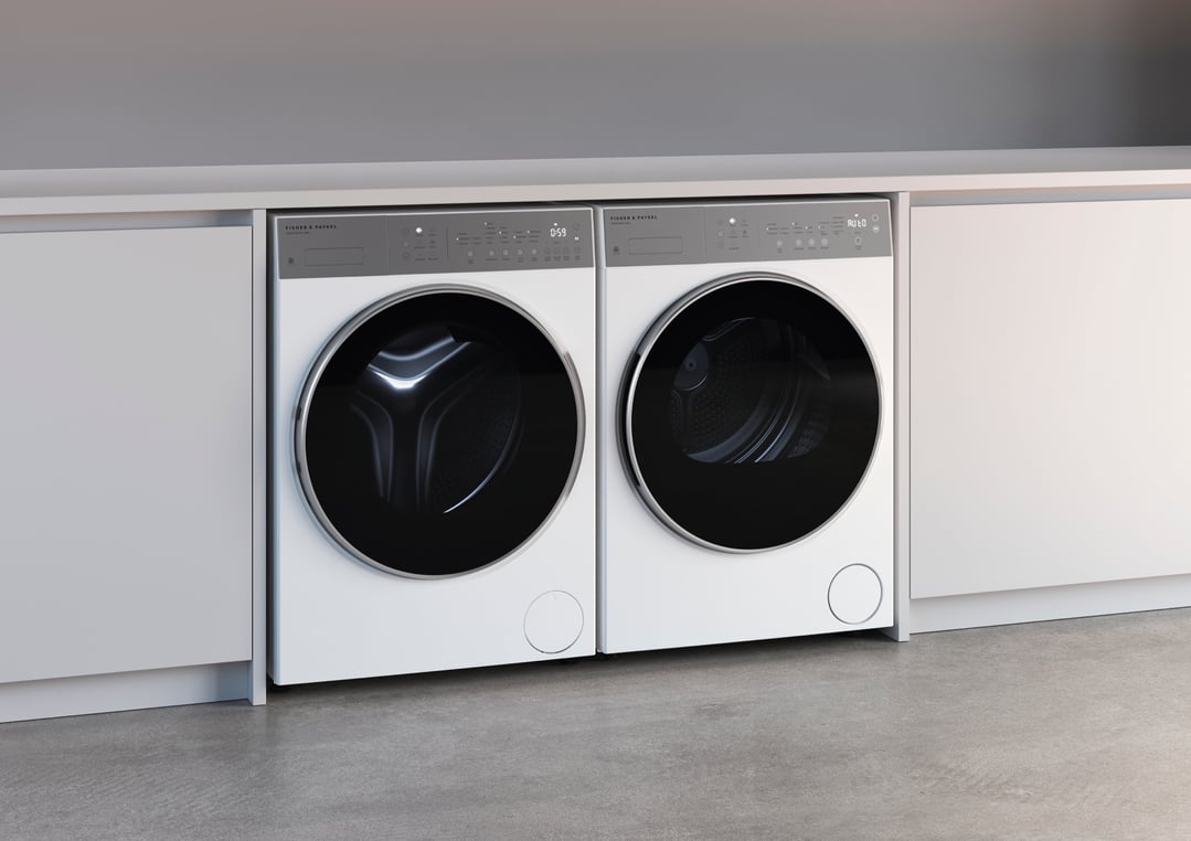 Two white front loader washing machines installed under a light grey countertop