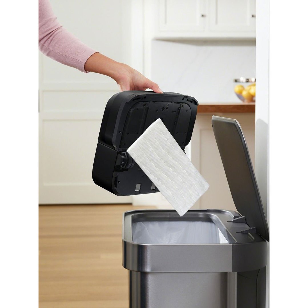 Hand removing a cleaning pad from a Braava Jet M6 robot mop over a bin