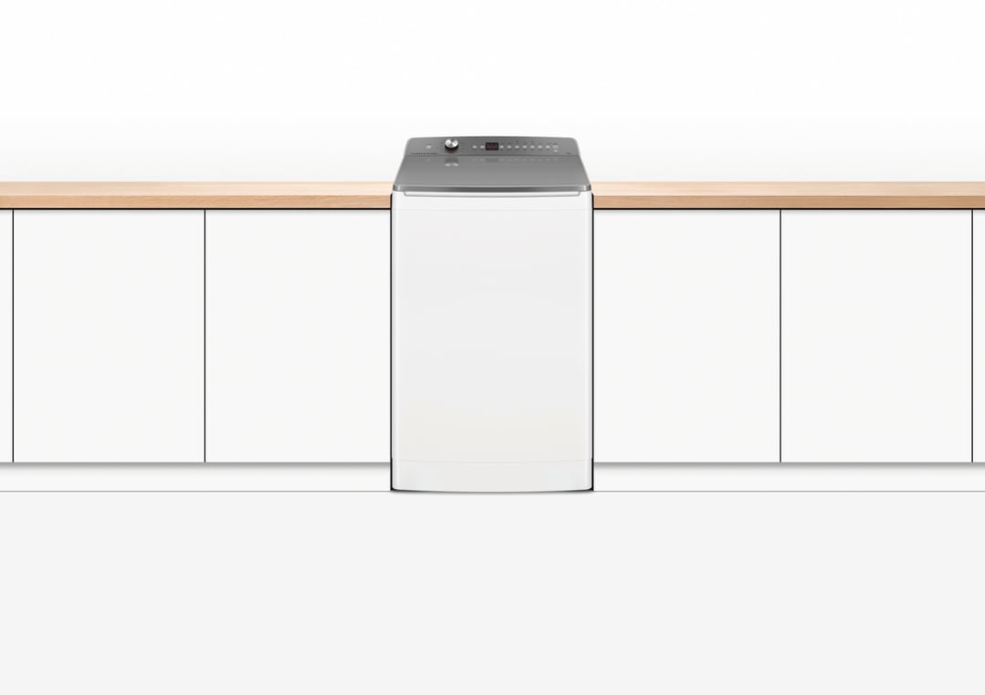 Fisher & Paykel washing machine integrated into a kitchen counter with white cabinets