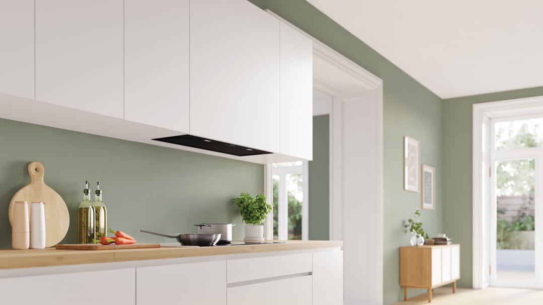 Black integrated rangehood installed above a cooktop in a modern kitchen