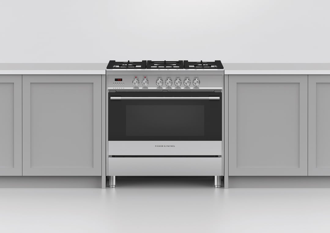 A stainless steel dual fuel cooker in a kitchen with light grey cabinets
