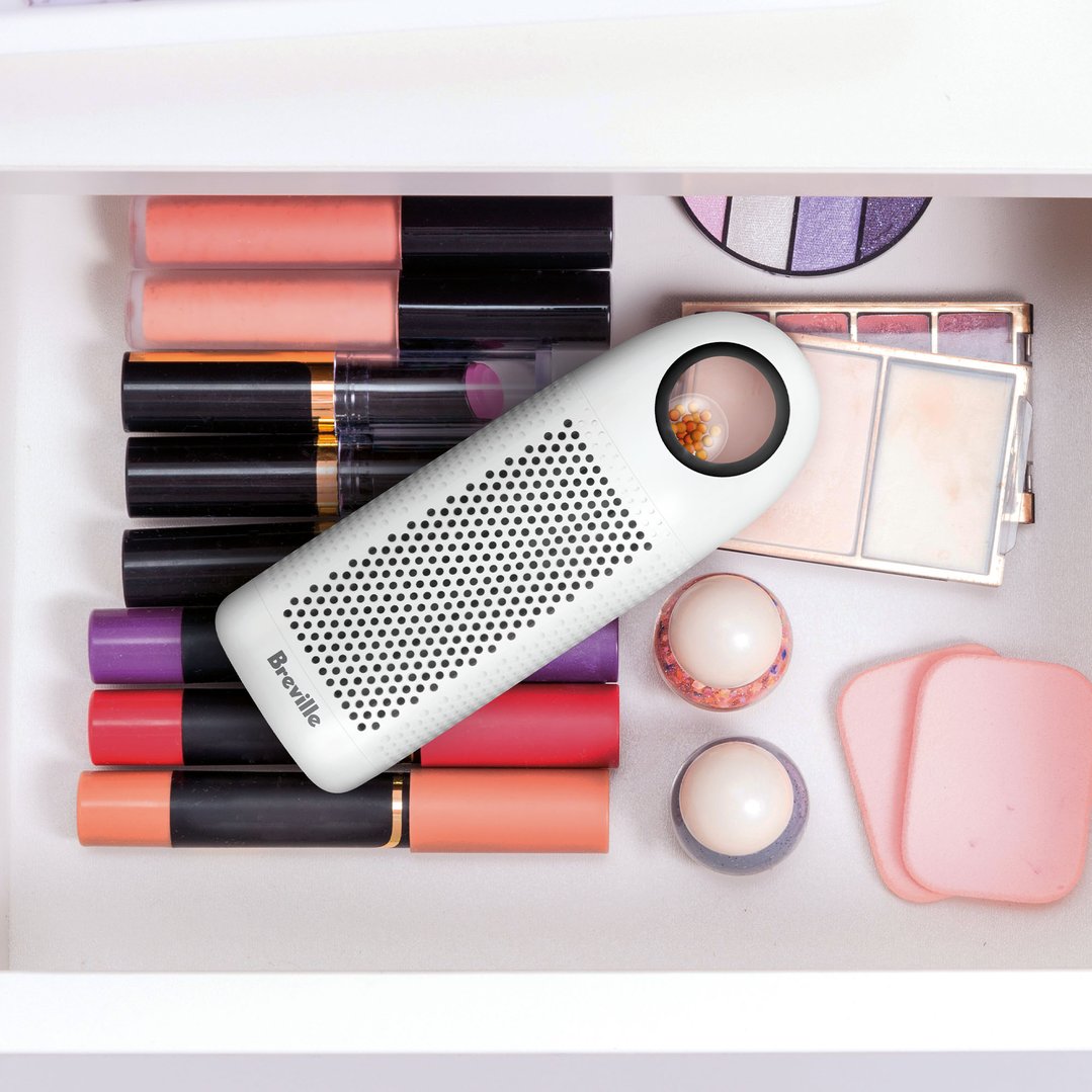 Breville dehumidifier in a drawer with various makeup products