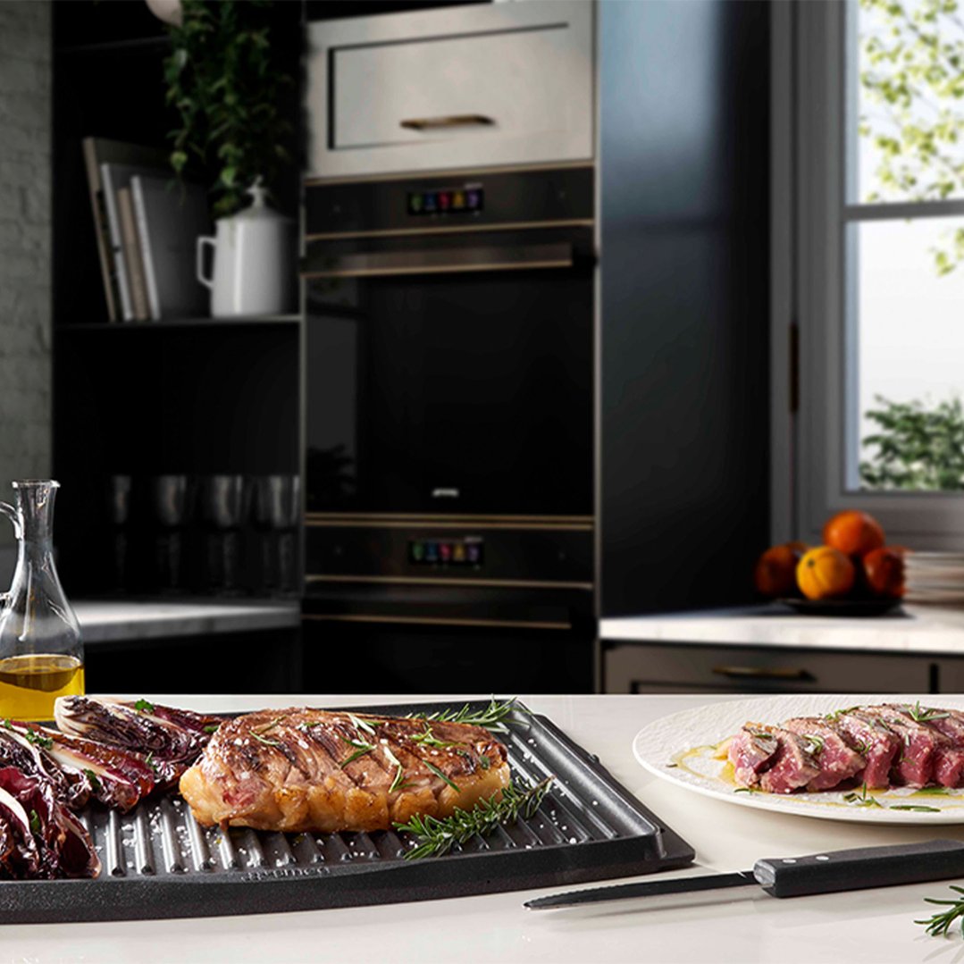 BBQ tray with grilled meat and vegetables in a modern kitchen setting
