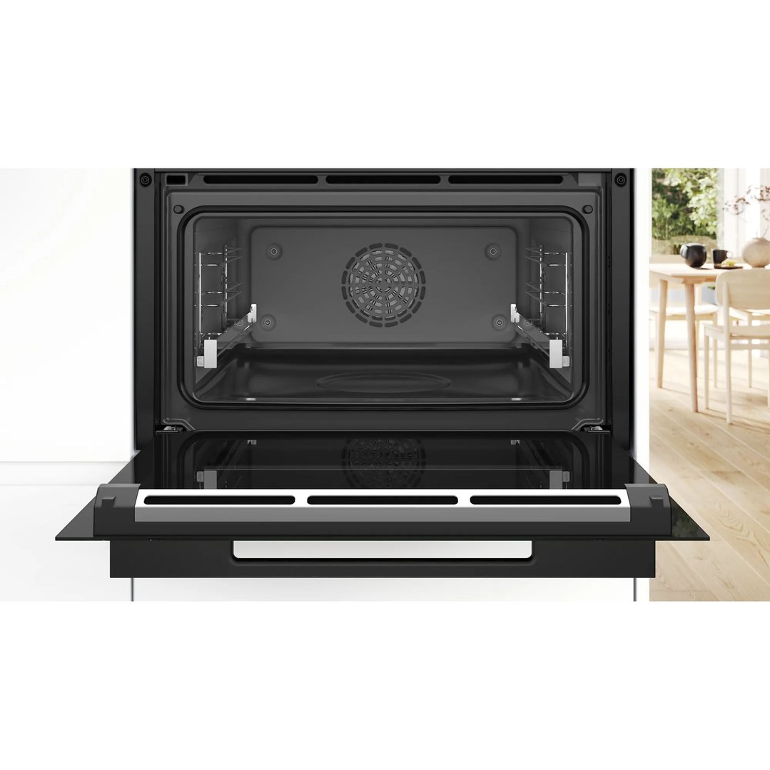 Open built-in compact oven with steam function in a kitchen setting