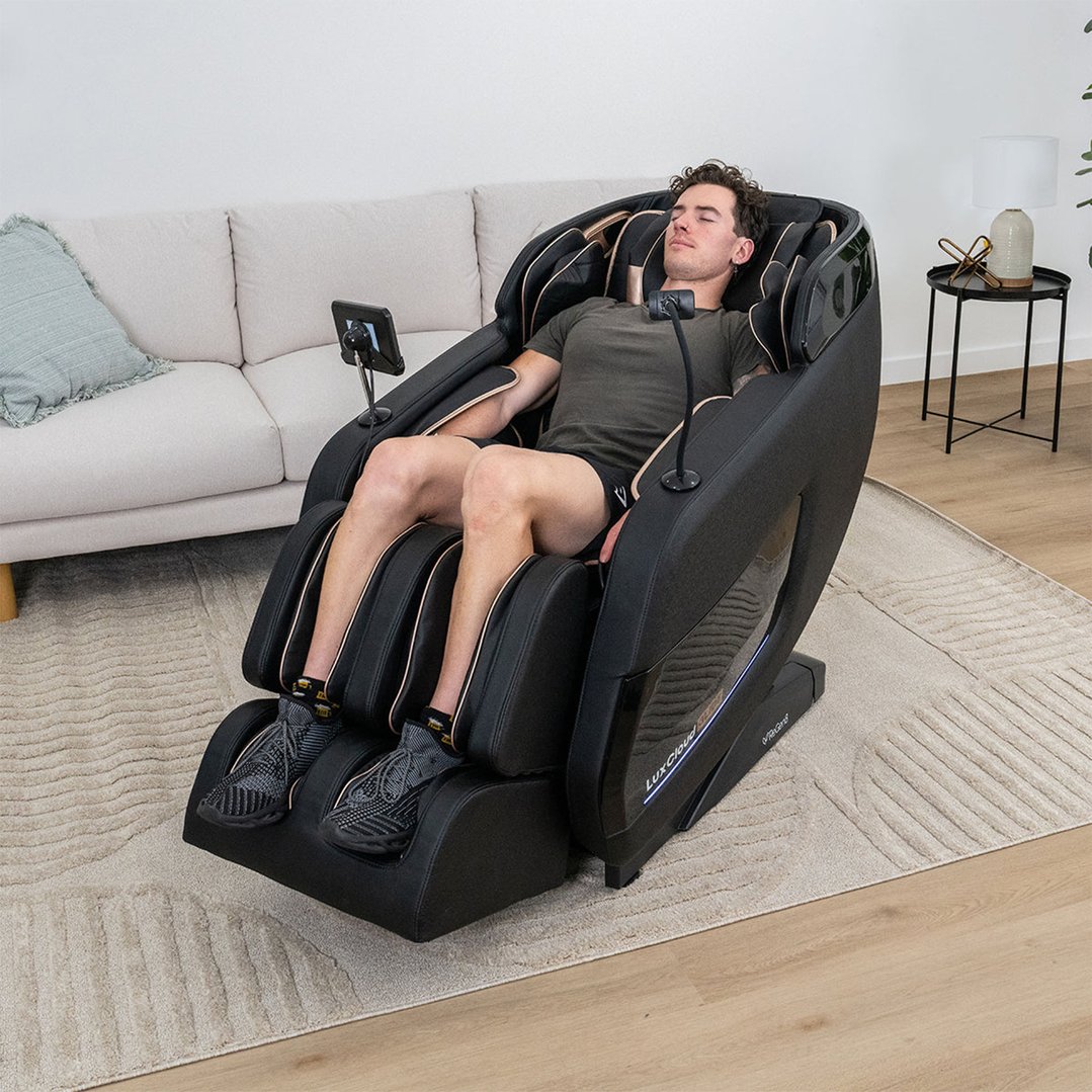 Man relaxing in a black massage chair in a living room setting