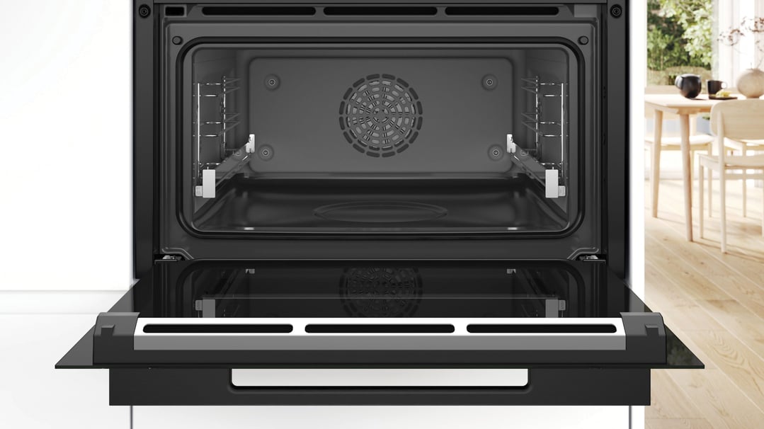Open built-in compact oven with steam function in a kitchen setting