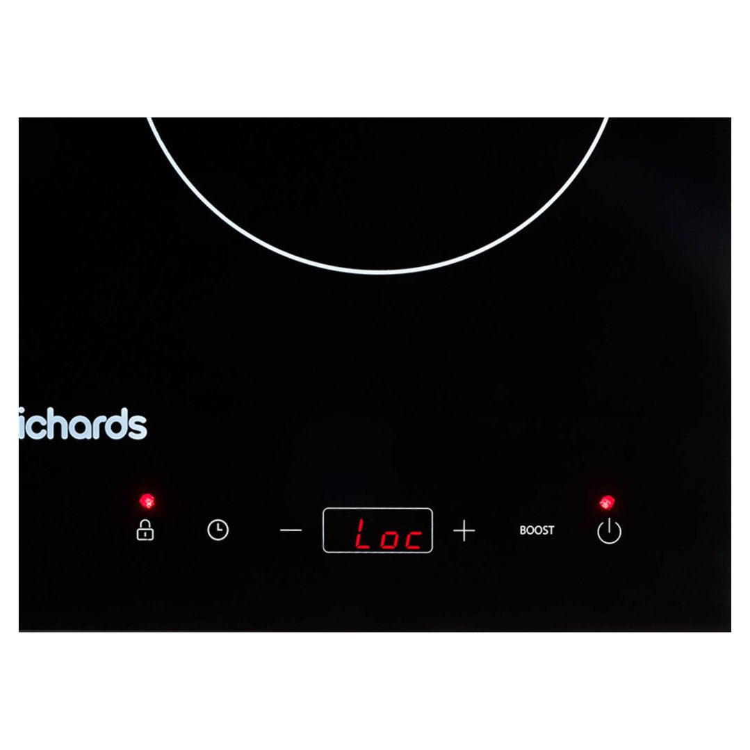 Close-up of a black induction cooktop with red digital display showing "Loc"